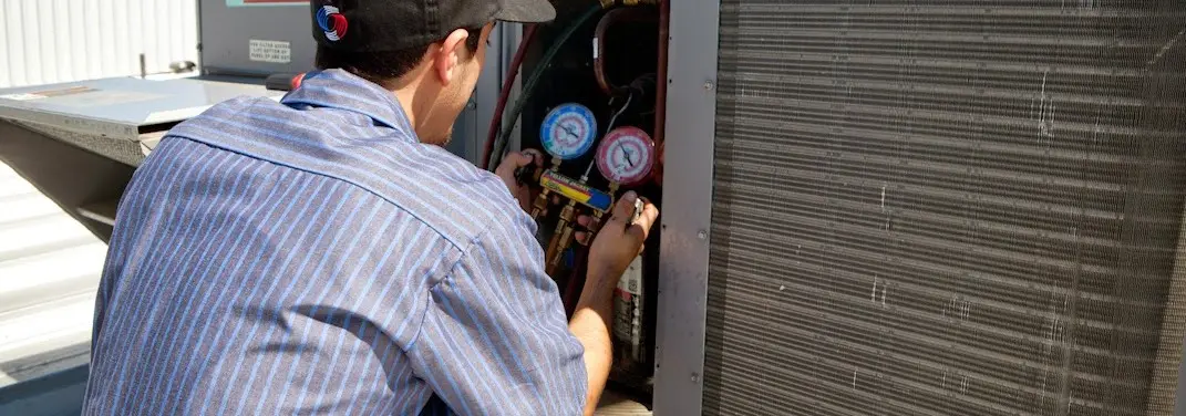 HVAC technician servicing a condenser unit in Marbletown